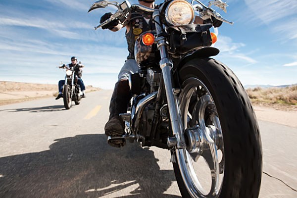 Close-up of motorcycle driving toward camera on a highway, with another biker behind.