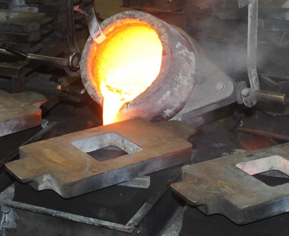 Melted brass/bronze alloy is poured into mold.