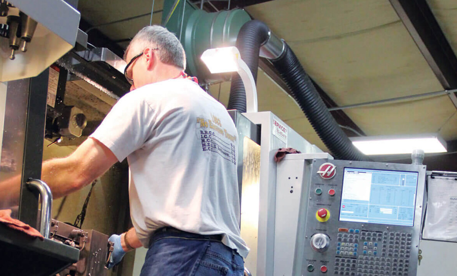 Dee Manufacturing worker operates machining equipment.