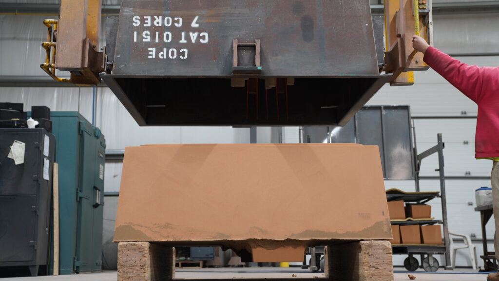 Wisconsin Aluminum Foundry worker operates removes cope from air set mold.
