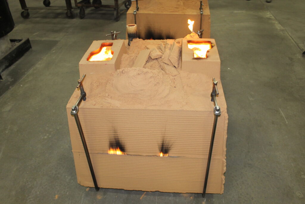 Wisconsin Aluminum Foundry sand mold filled with melted brass and bronze alloy.