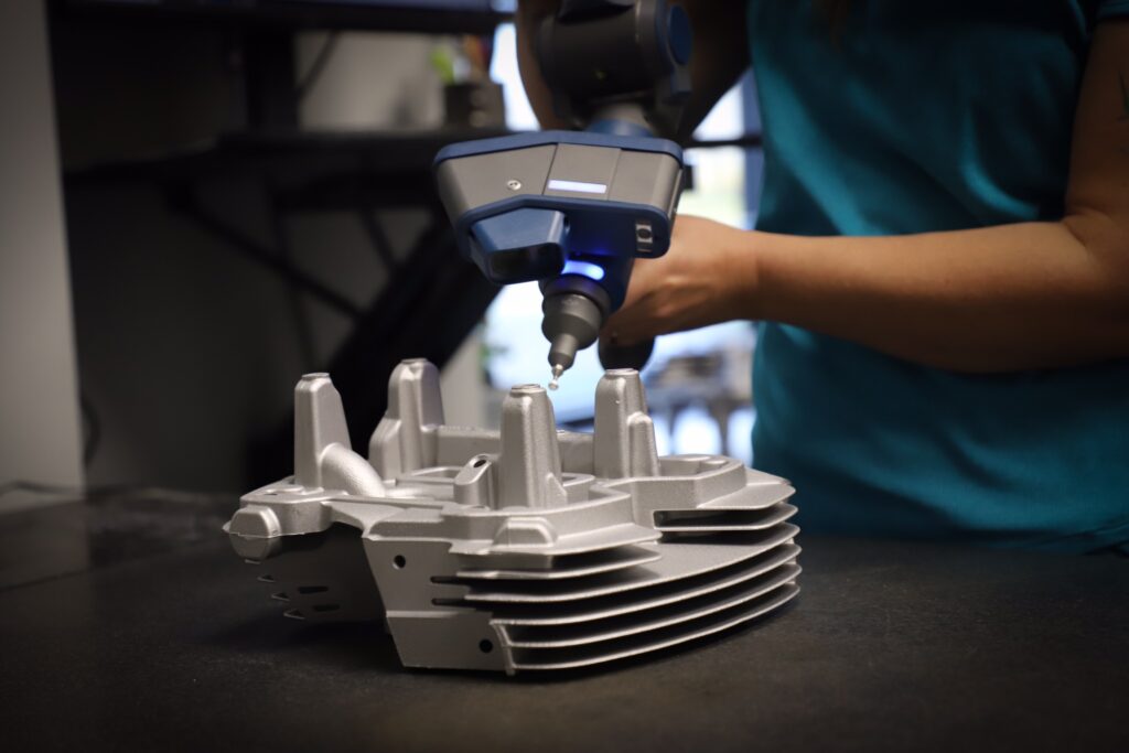 Engineer uses inspection equipment to scan a cast metal part.
