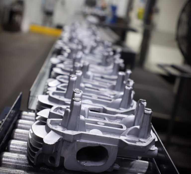 Cast metal parts on a conveyor line at ATEK Metal Technologies, a Wisconsin Aluminum Foundry company in Iowa.