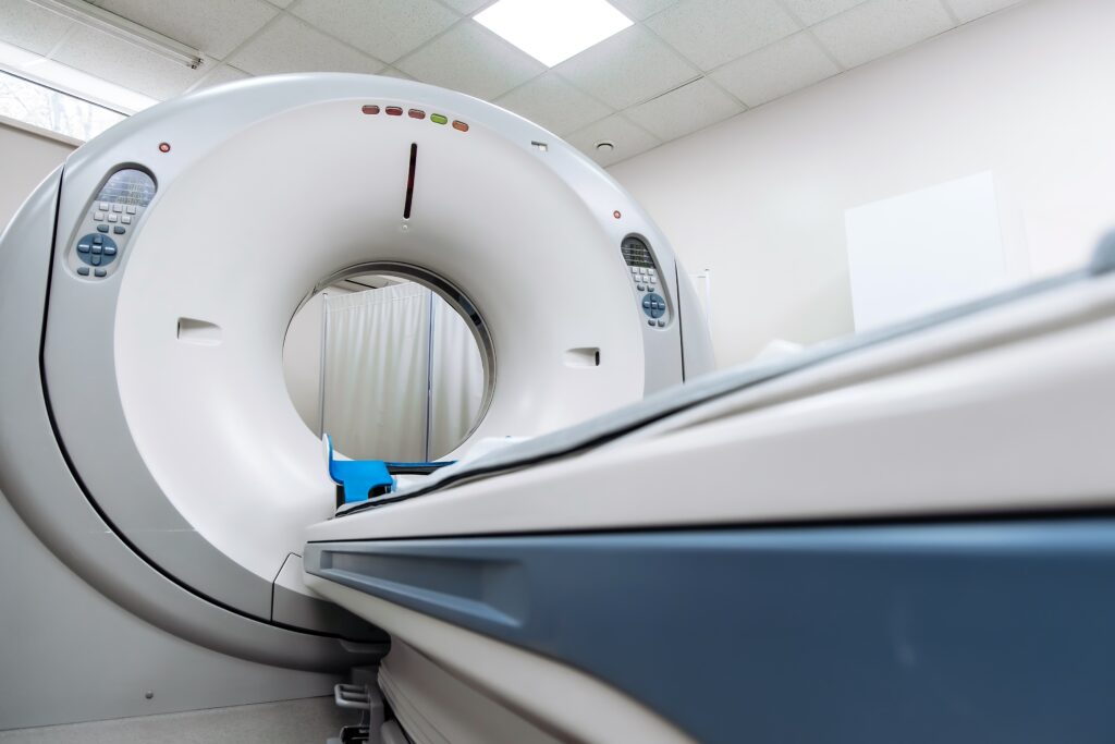 A low, angled view of a CAT scan machine in a medical room.